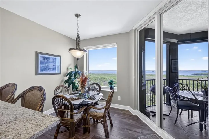 Dining area with dark wood-style floors and a water view