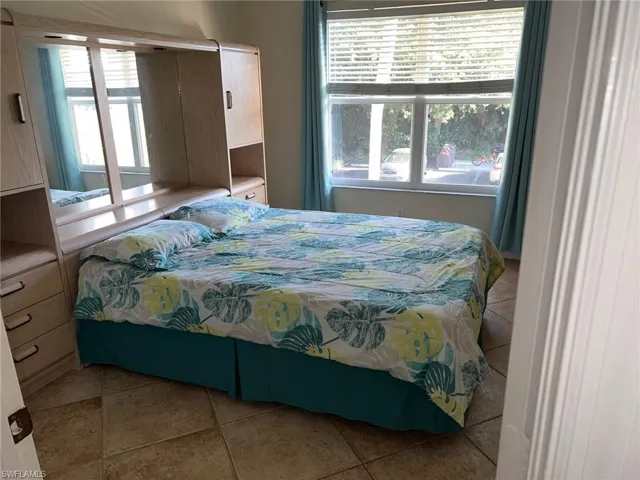 Bedroom featuring light tile patterned flooring and multiple windows