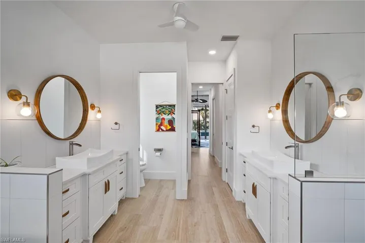 Bathroom with vanity, toilet, wood-type flooring, and ceiling fan