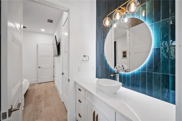 Bathroom featuring tile walls, vanity, and wood-type flooring