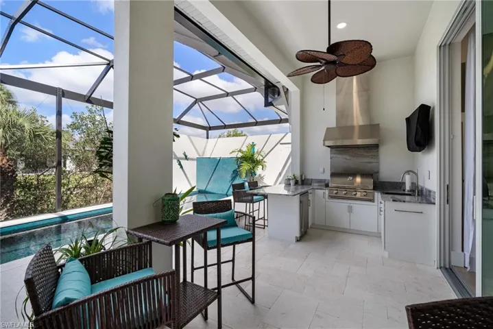 Sunroom / solarium featuring ceiling fan, sink, and a swimming pool