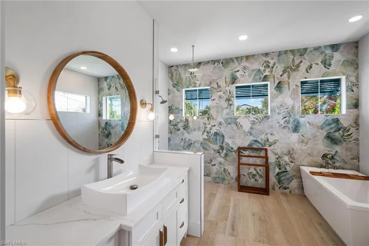 Bathroom with vanity, a tub, and hardwood / wood-style flooring