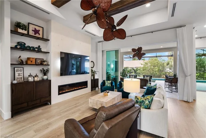 Living room with ceiling fan, light wood-type flooring, and a fireplace