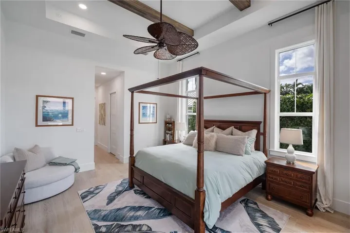 Bedroom with multiple windows, light hardwood / wood-style floors, and ceiling fan