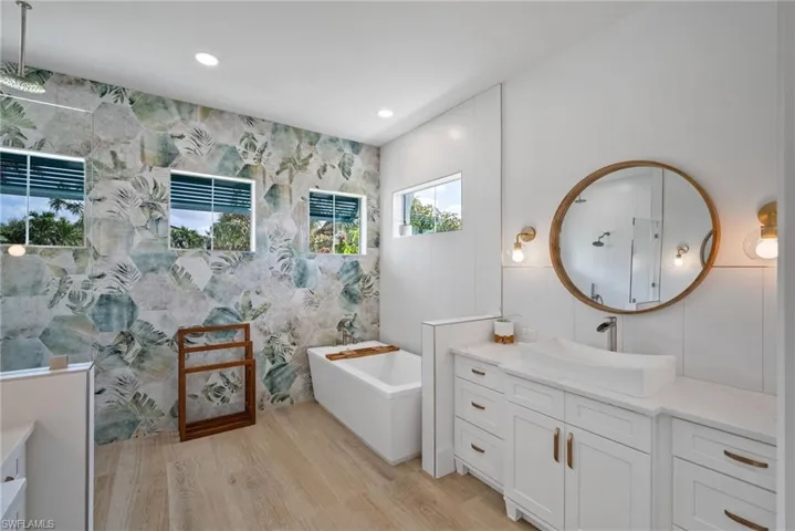 Bathroom featuring vanity, wood-type flooring, and a bathing tub