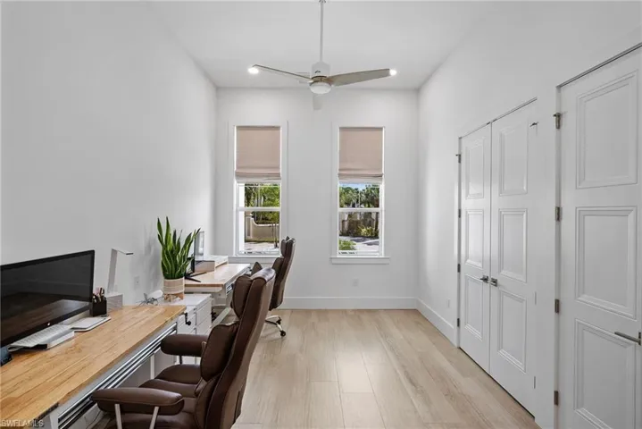 Office area with light hardwood / wood-style flooring and ceiling fan