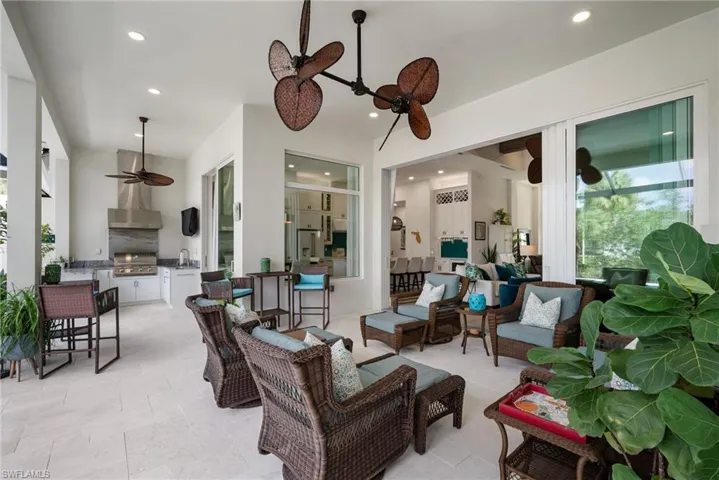 View of patio featuring exterior kitchen, ceiling fan, an outdoor living space, sink, and a grill
