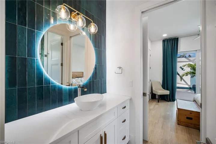 Bathroom with vanity, tile walls, and hardwood / wood-style floors