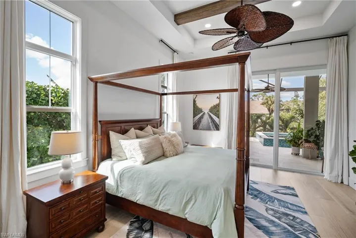 Bedroom with multiple windows, access to exterior, light wood-type flooring, and ceiling fan