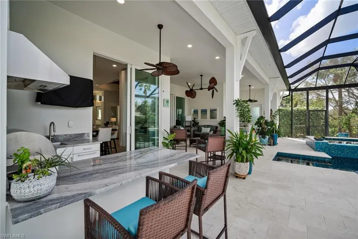 View of patio / terrace with ceiling fan, a lanai, a pool with hot tub, and sink