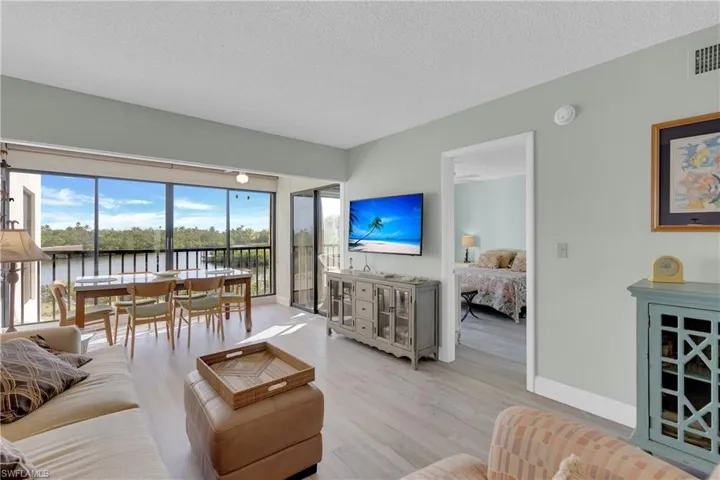 Living area with light wood-type flooring and a textured ceiling