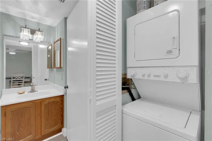 Laundry area with stacked washer / drying machine and a ceiling fan