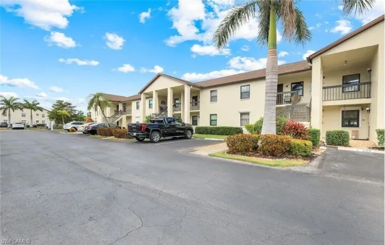 View of apartment building / complex with uncovered parking