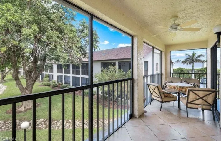 Sunroom with ceiling fan and a balcony