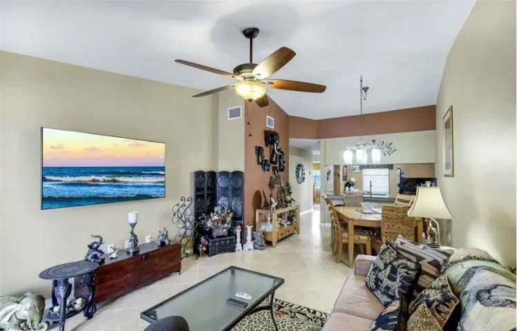Living room with ceiling fan, a chandelier, and light tile patterned flooring