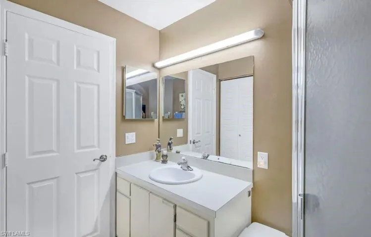 Bathroom featuring vanity, a closet, and a shower stall