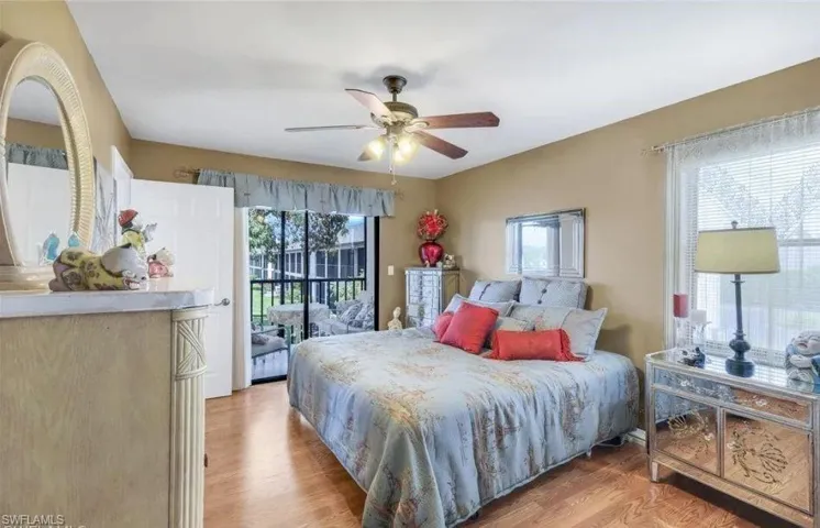 Bedroom featuring access to exterior, light wood finished floors, and a ceiling fan