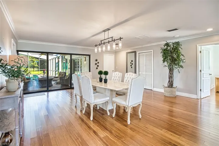 Dining space featuring light wood-style flooring, ornamental molding, and track lighting