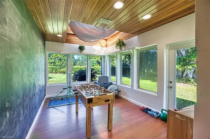 Playroom featuring wooden ceiling, wood finished floors, recessed lighting, and a textured wall