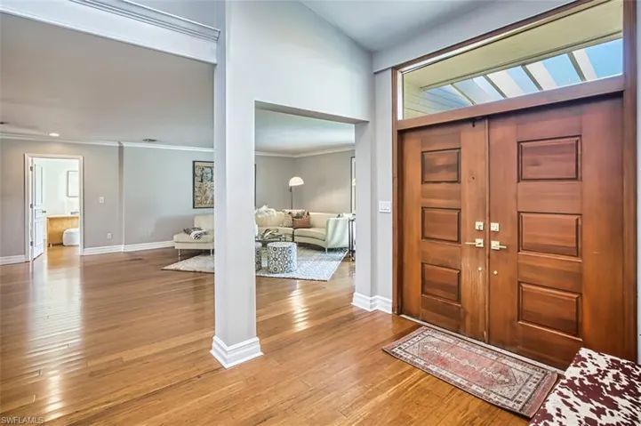 Foyer featuring light wood-style floors and crown molding
