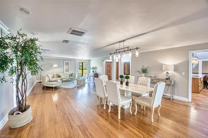 Dining space featuring light wood-style flooring, ornamental molding, and track lighting