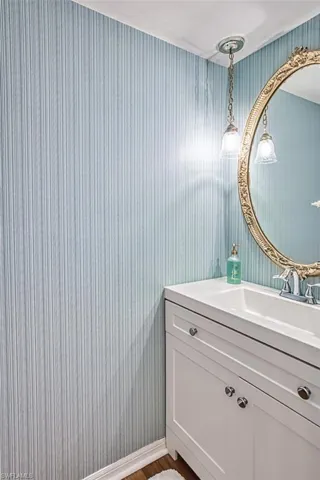 Bathroom with vanity and wallpapered walls