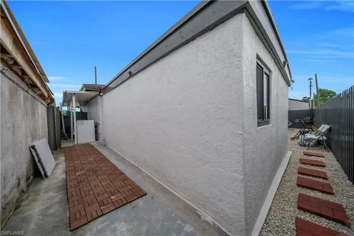Exterior stucco finish, brown window trim, and a low-profile roofline