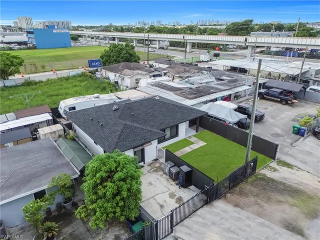 Newly roofed property featuring a fenced yard with artificial turf, a concrete patio area, and an exterior with white siding