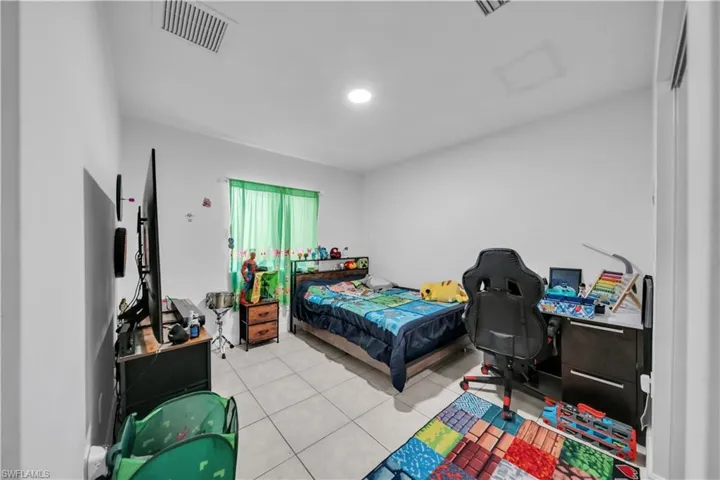 Room with light-toned tile flooring and white walls