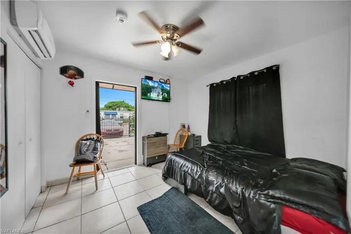Interior space featuring white tile flooring, ceiling fan with light fixture, and an exterior door providing direct outdoor access