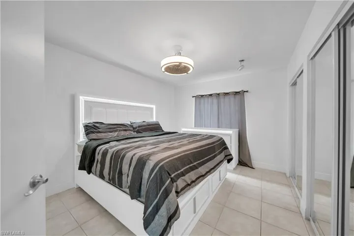 Bright interior with tile flooring, a contemporary ceiling fan, mirrored closet doors, and recessed lighting