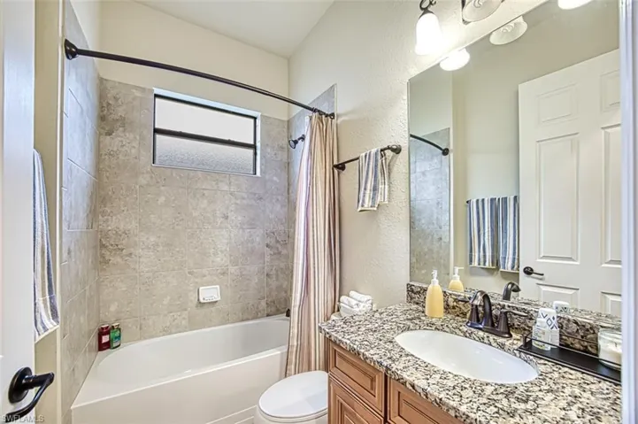 Full bathroom featuring vanity, toilet, shower / tub combo
