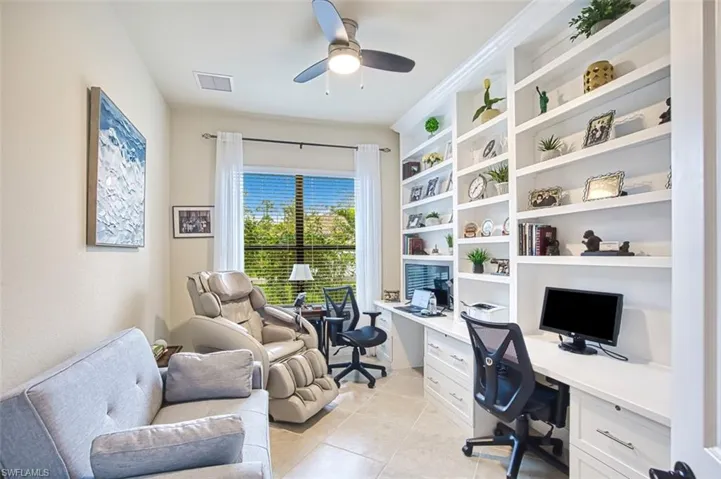 Office space with built in features, a ceiling fan, light tile patterned flooring, and built in desk