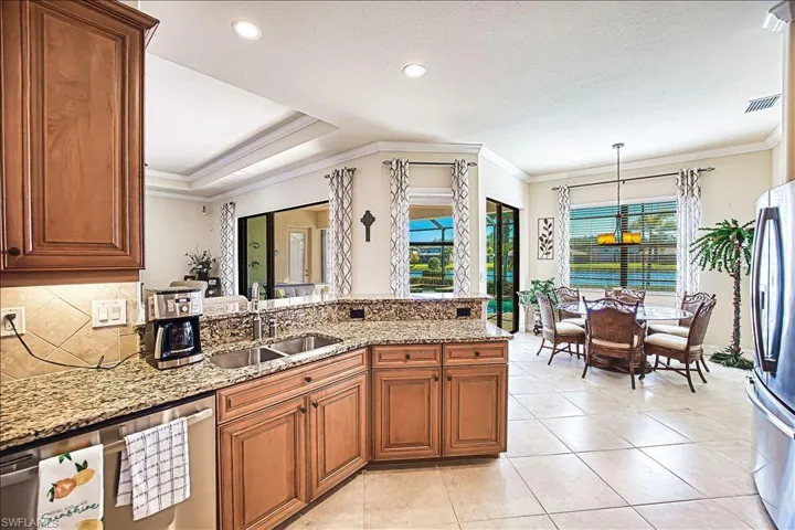 Kitchen featuring visible vents, stainless steel appliances, a sink, crown molding, and backsplash