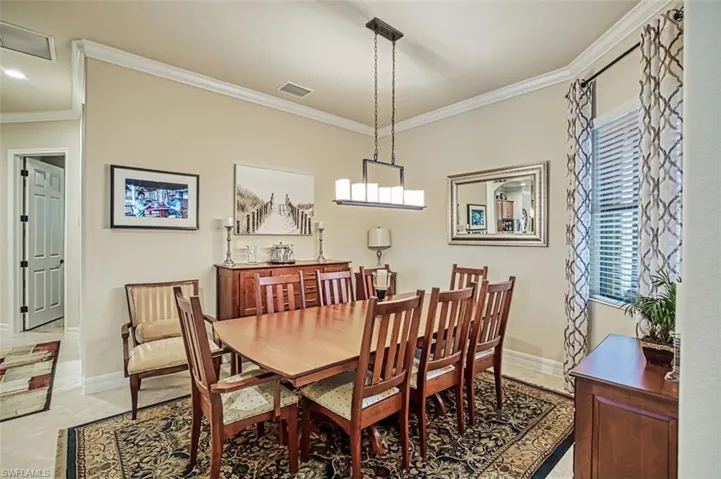 Dining room with light tile patterned floors & crown molding