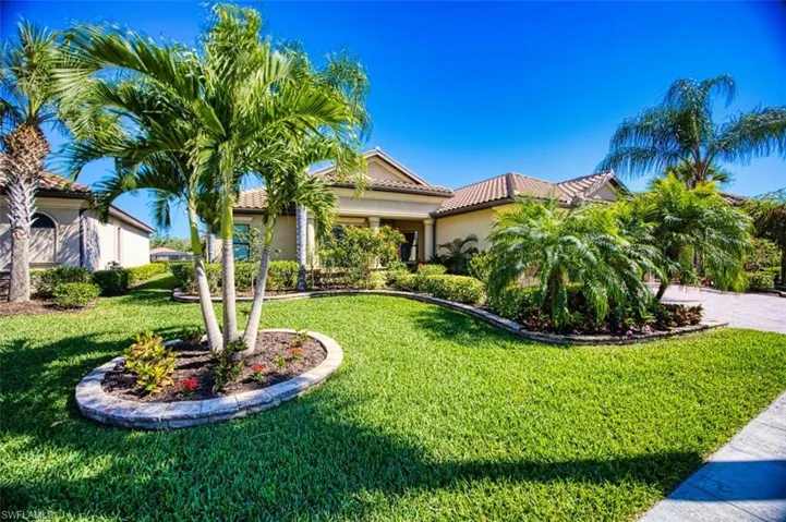Mediterranean / spanish-style home with stucco siding, a garage, a front yard, and a tile roof