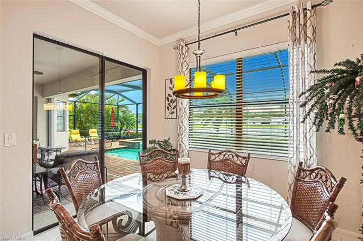 Dining space with a sunroom and ornamental molding