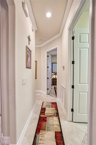 Hallway with tall ceilings, crown molding