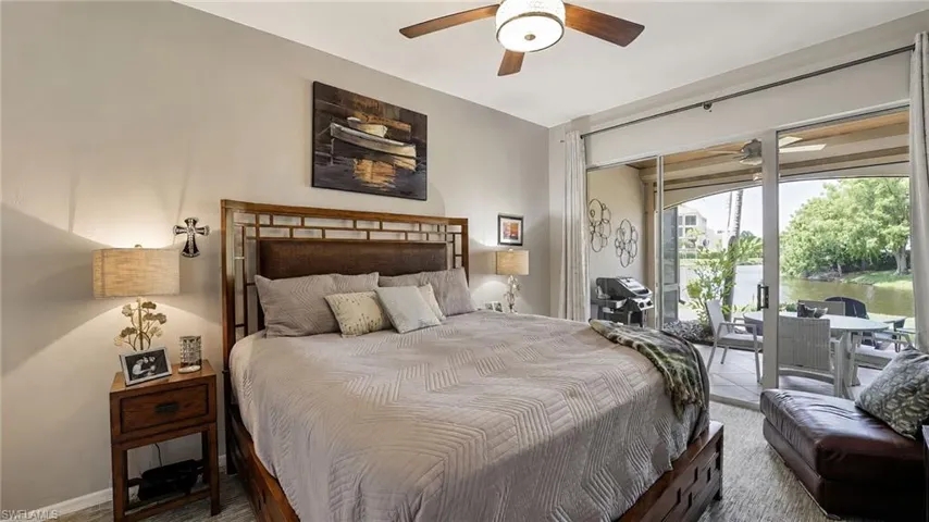 The oversized primary bedroom located on the first level offers direct access to the lanai, creating a serene and private retreat perfect for enjoying your morning coffee in a peaceful, tranquil setting, complete with plush carpeting that adds warmth and comfort underfoot.