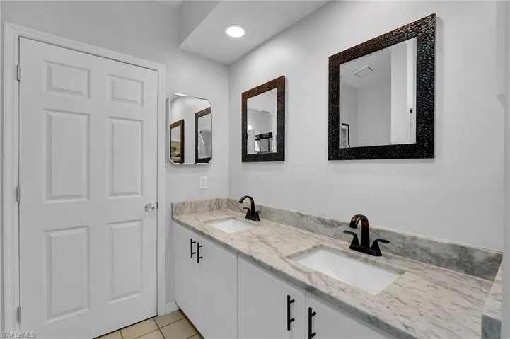 The second full bath on the upper level is thoughtfully designed as a shared bath between the two suites, offering a tub and shower combination along with a newly upgraded dual quartz-topped vanity—blending style, comfort, and functionality for guests and family alike.