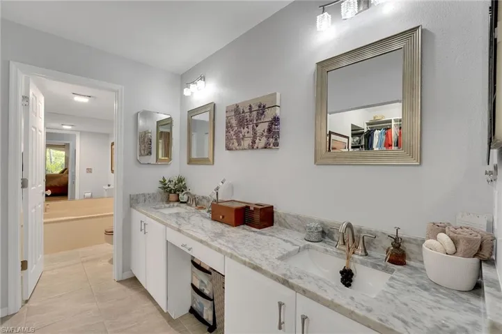 The reimagined primary bathroom showcases dual quartz-topped vanities, a dedicated dressing area, new designer lighting and mirrors, and upgraded hardware throughout. A separate soaking tub and walk-in shower complete this spa-inspired retreat, blending modern elegance with refined functionality.
