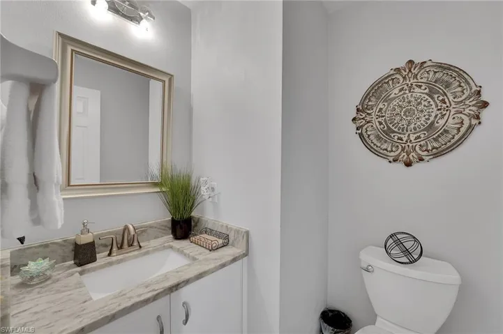 The powder bath is conveniently located on the first level and has been thoughtfully updated with a new quartz-topped vanity and stylish new lighting, offering a refined and elegant touch for guests.