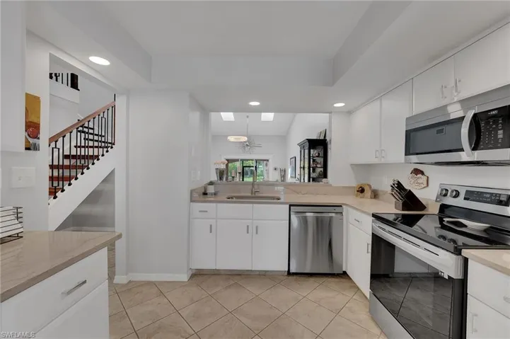 The kitchen has been beautifully updated with new quartz countertops, refined hardware, and brand-new appliances, all complemented by an elegant tray ceiling. An expanded opening into the dining and living areas enhances the flow of the home, framing perfect, uninterrupted views and creating an ideal setting for both everyday living and entertaining.