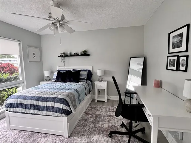 Queen bed with desk area and large closet with ceiling fan.