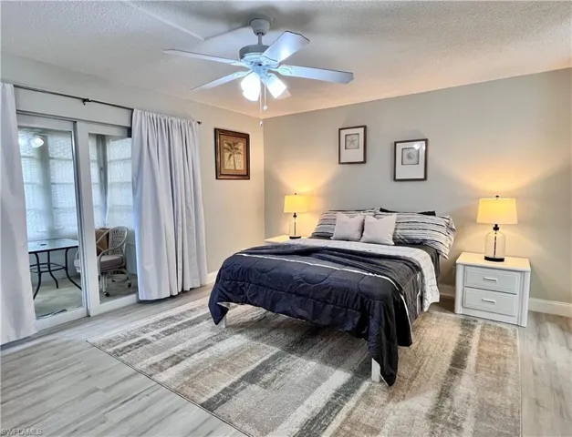 Queen Bed - plank finished floors, a textured ceiling, and a ceiling fan