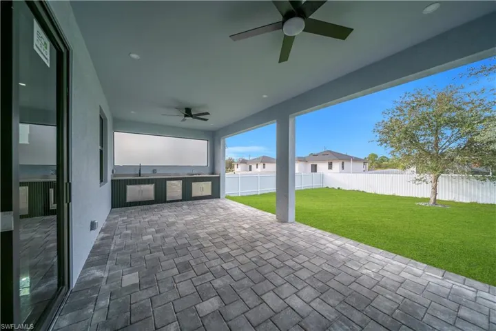 Fenced backyard featuring a ceiling fan and a patio