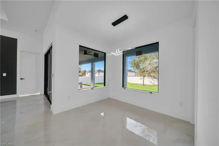 Unfurnished dining area featuring baseboards and suspended lighting