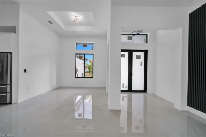 Foyer entrance featuring a tray ceiling and baseboards