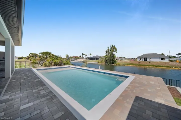 Outdoor pool featuring a patio area and a water view