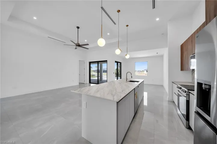 Kitchen with modern cabinets, pendant lighting, open floor plan, stainless steel appliances, and recessed lighting